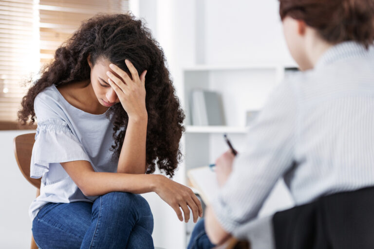 woman with head in hands during therapy session