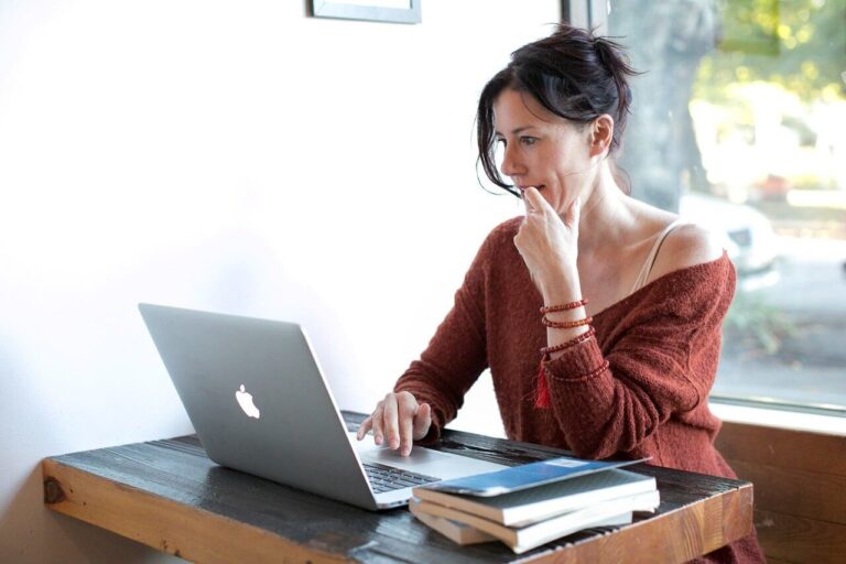 woman sat at table during online therapy