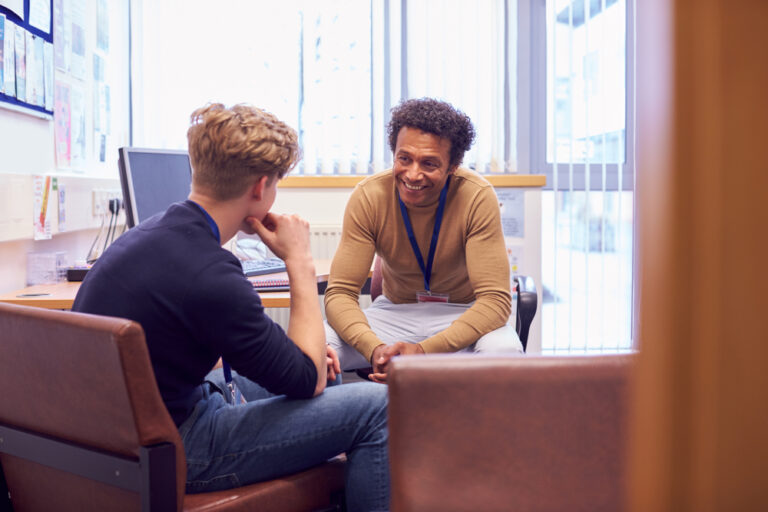 young man speaking to smiling therapist during counselling session