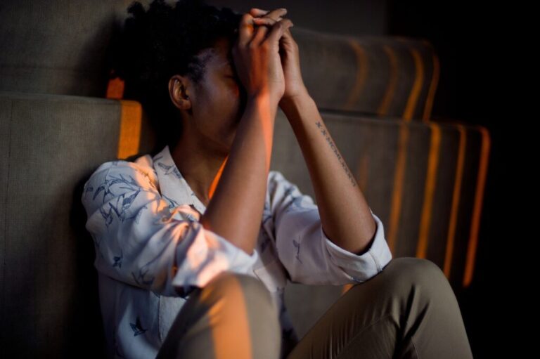 woman sat on floor with head in hands